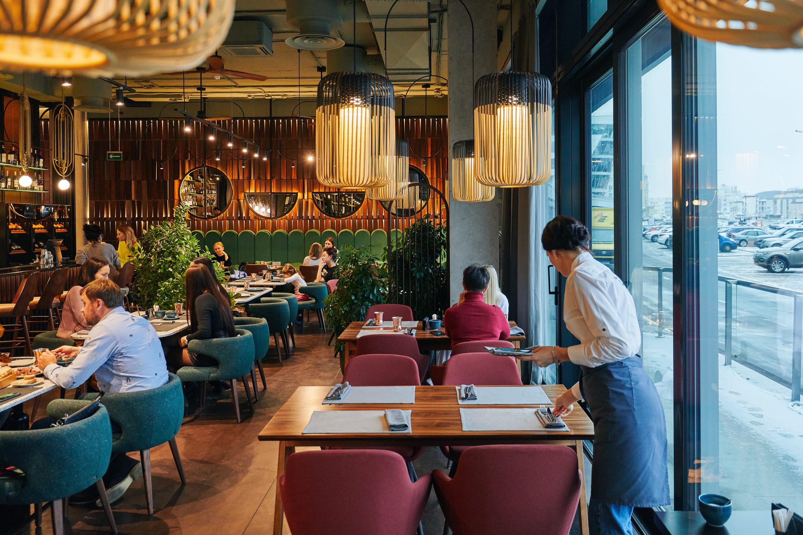 a restaurant with people and waiters, with large windows, the interior in a modern style